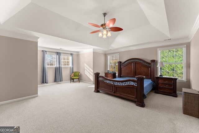 carpeted bedroom featuring a raised ceiling, ceiling fan, crown molding, and multiple windows