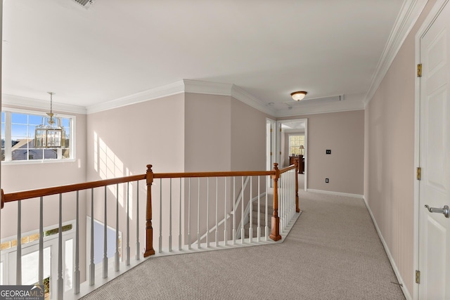 hall featuring a healthy amount of sunlight, a notable chandelier, and ornamental molding