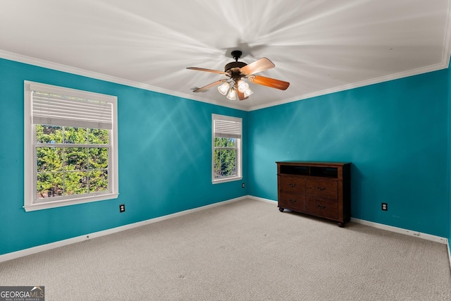 carpeted spare room featuring ceiling fan and crown molding