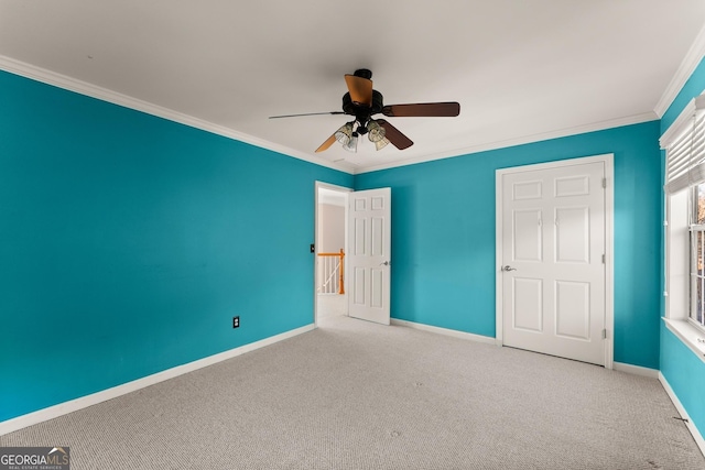 unfurnished bedroom with ceiling fan, carpet floors, and crown molding