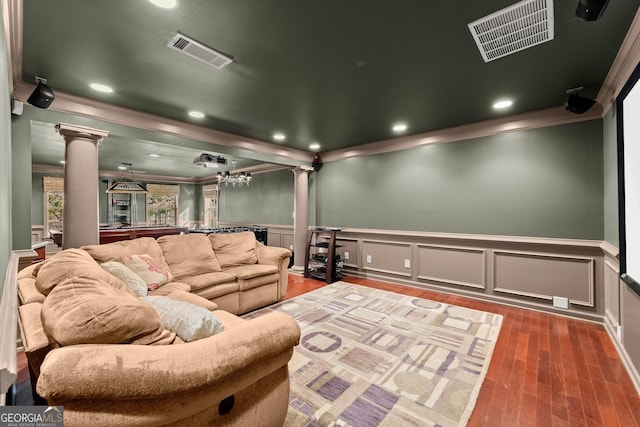 cinema with hardwood / wood-style floors, crown molding, and decorative columns