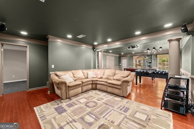 living room with ornate columns, crown molding, and hardwood / wood-style flooring