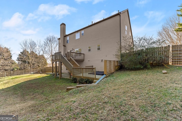 rear view of house featuring a deck and a lawn