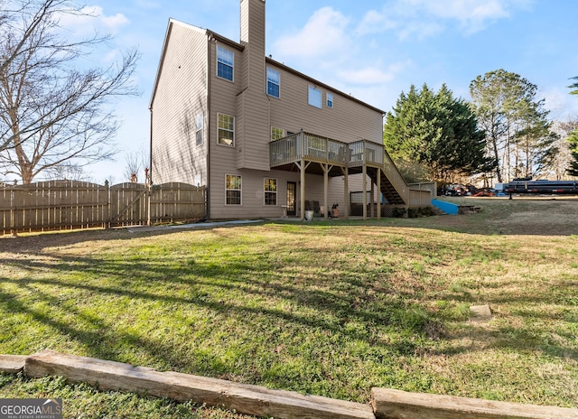 rear view of house with a deck and a yard