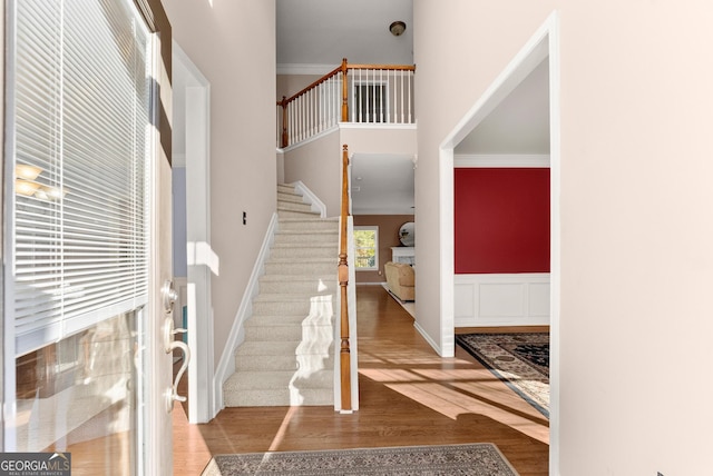 entrance foyer with crown molding and hardwood / wood-style floors