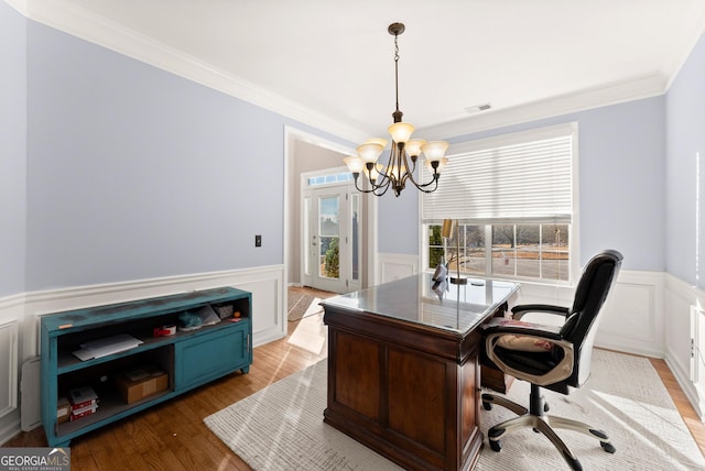 home office with light hardwood / wood-style floors, a chandelier, and ornamental molding