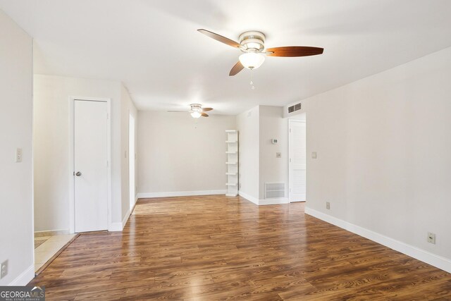 spare room featuring beam ceiling, ceiling fan, dark wood-type flooring, and a textured ceiling