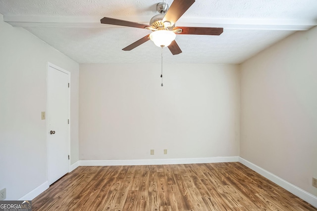 spare room with beam ceiling, ceiling fan, a textured ceiling, and hardwood / wood-style flooring