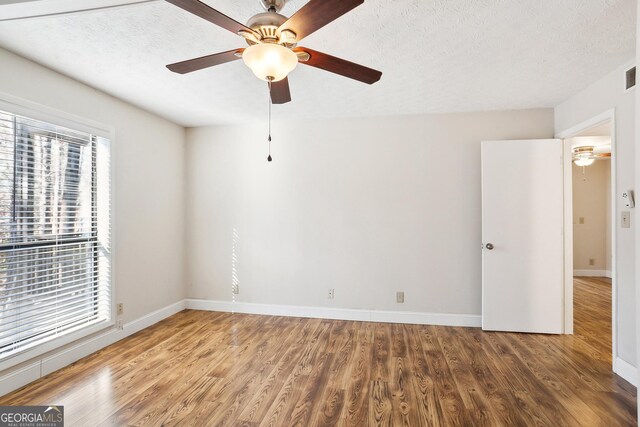 laundry area featuring water heater, stacked washer and dryer, and cabinets