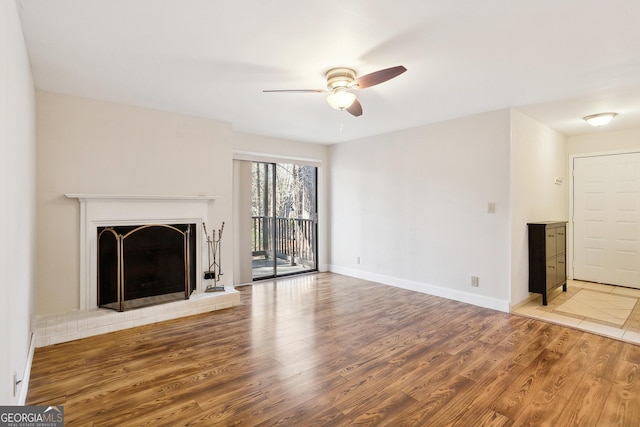 unfurnished living room featuring a fireplace, hardwood / wood-style floors, and ceiling fan