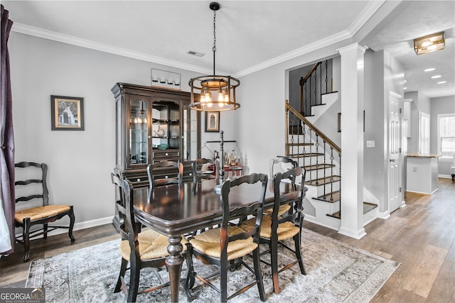 dining area featuring an inviting chandelier, decorative columns, crown molding, hardwood / wood-style floors, and a textured ceiling