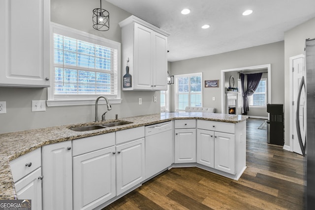 kitchen with dishwasher, white cabinetry, and sink