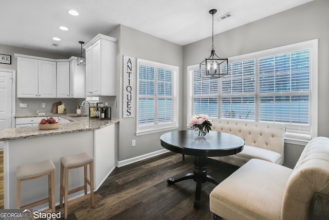 dining space featuring a notable chandelier, breakfast area, dark hardwood / wood-style flooring, and sink