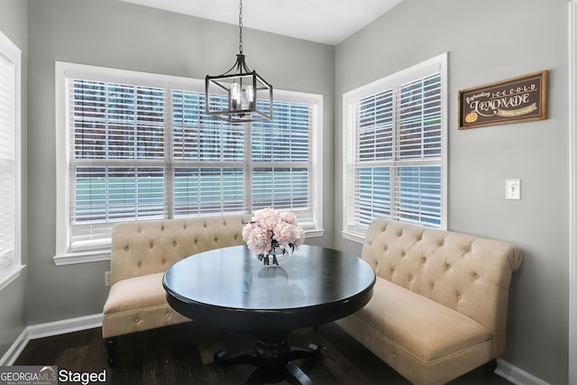 dining area featuring hardwood / wood-style floors, breakfast area, and an inviting chandelier