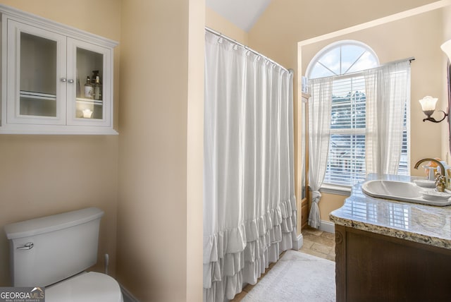 bathroom with vanity, toilet, and vaulted ceiling