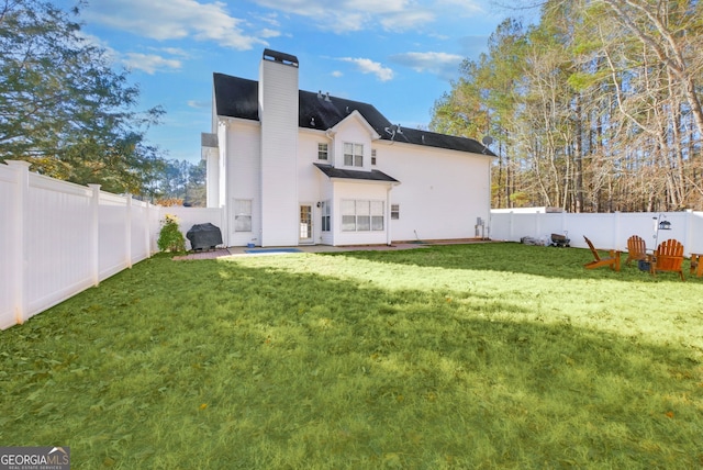 rear view of house with a patio area and a lawn