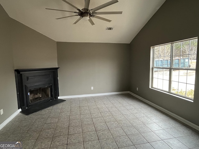 unfurnished living room with ceiling fan, a healthy amount of sunlight, light tile patterned flooring, and lofted ceiling