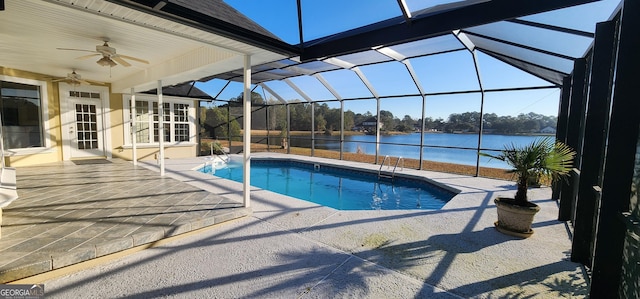 view of swimming pool with ceiling fan, a water view, a patio, and glass enclosure