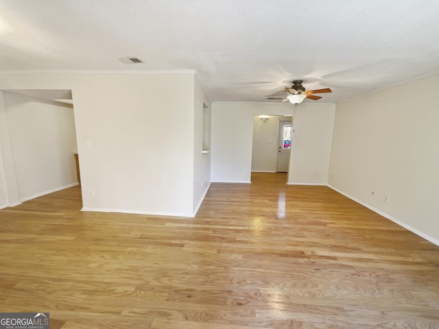 spare room with a textured ceiling, light hardwood / wood-style floors, ceiling fan, and ornamental molding