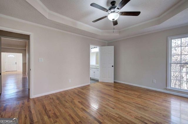 spare room with dark hardwood / wood-style flooring, a raised ceiling, and crown molding