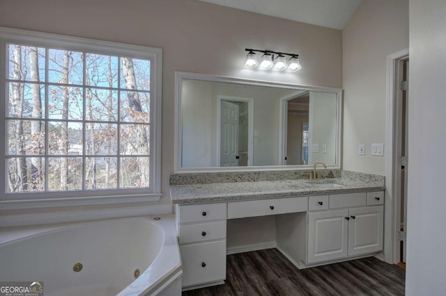 bathroom featuring vanity, hardwood / wood-style flooring, and a tub