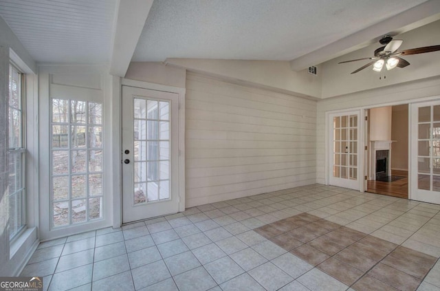 unfurnished sunroom with french doors, vaulted ceiling with beams, and ceiling fan