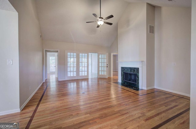 unfurnished living room featuring a fireplace, hardwood / wood-style flooring, high vaulted ceiling, and ceiling fan