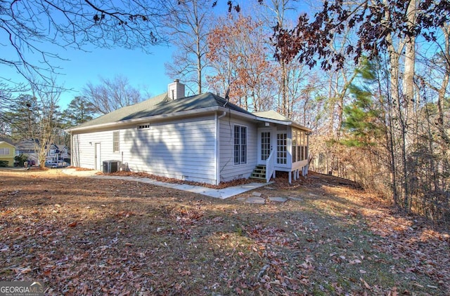 view of side of property with a sunroom and central AC unit