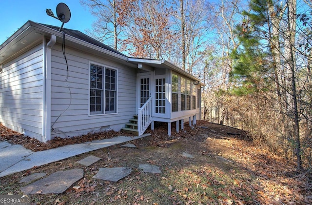 view of property exterior with a sunroom