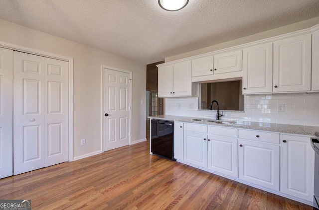 kitchen featuring white cabinetry, sink, and black dishwasher