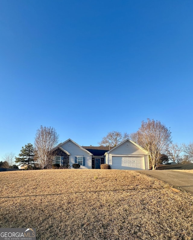 ranch-style home featuring a garage and a front yard