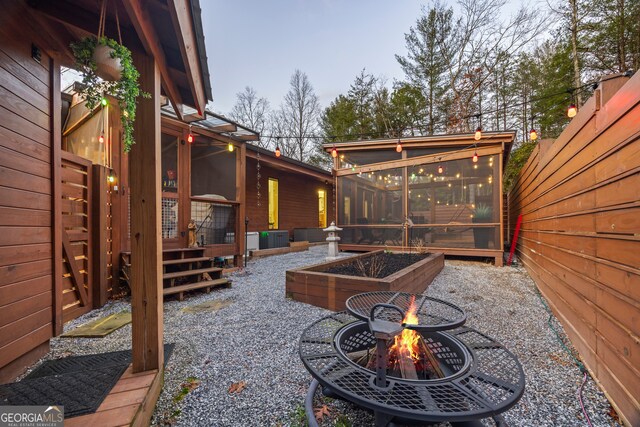 view of patio with a fire pit and a sunroom