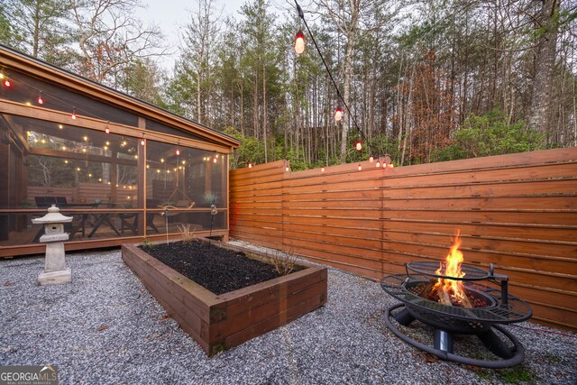 view of patio / terrace with a sunroom and an outdoor fire pit