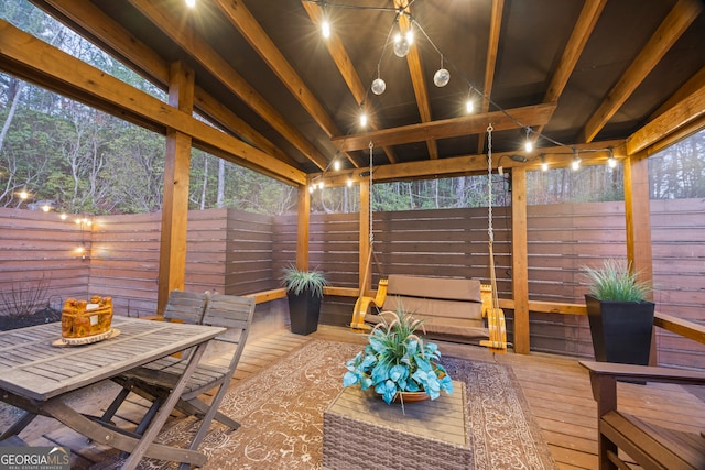 sunroom featuring a wealth of natural light and vaulted ceiling with beams