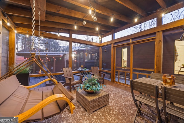 sunroom featuring plenty of natural light and beam ceiling