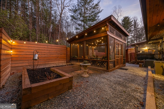 exterior space featuring a sunroom and cooling unit