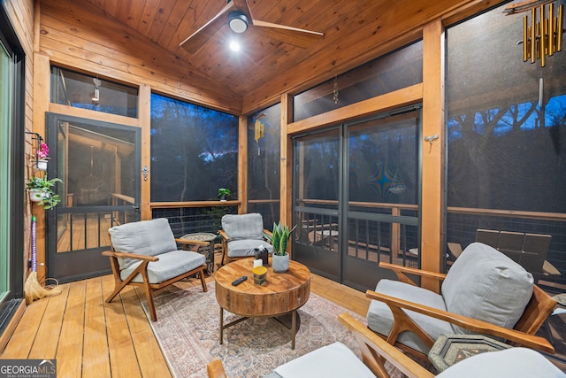 sunroom / solarium featuring lofted ceiling, wooden ceiling, and ceiling fan