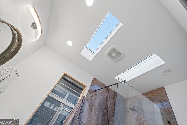 dining area with a skylight, a chandelier, and a high ceiling