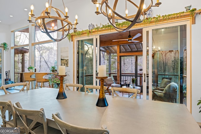 dining area featuring ceiling fan with notable chandelier