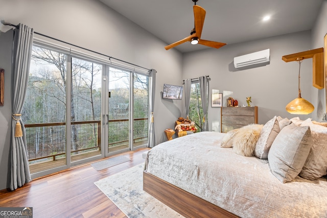 bedroom with ceiling fan, a wall mounted AC, hardwood / wood-style floors, and access to outside