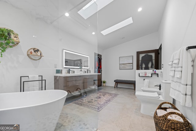 bathroom with toilet, a skylight, a bidet, vanity, and a bath