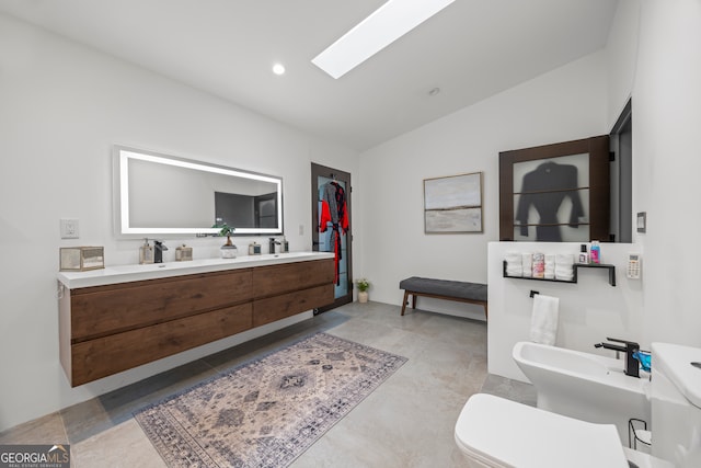 bathroom featuring vanity, lofted ceiling with skylight, toilet, and a bidet