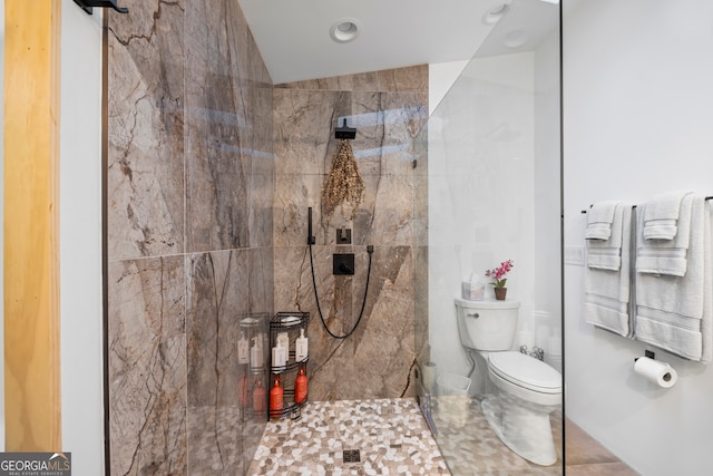 bathroom with tiled shower and toilet