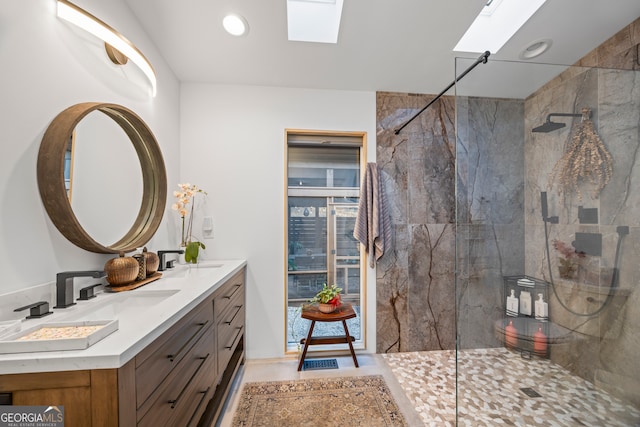 bathroom featuring vanity, a skylight, and a tile shower