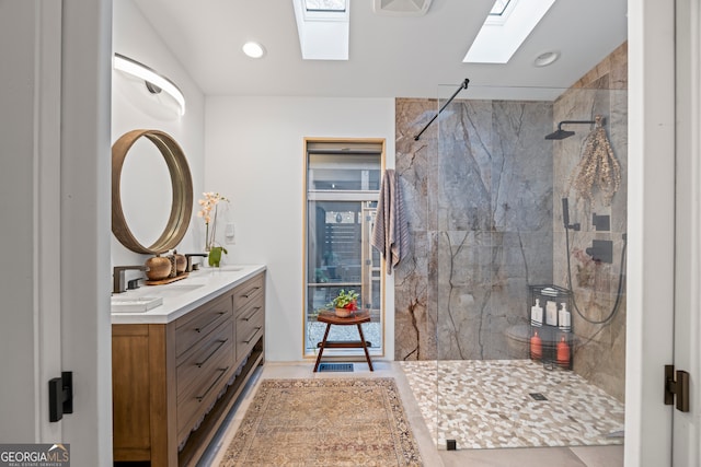 bathroom featuring tiled shower, vanity, and a skylight