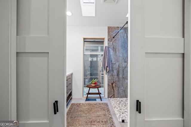 bathroom with vanity, an enclosed shower, and a skylight