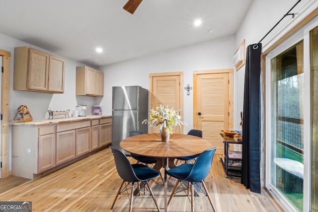 dining space featuring lofted ceiling and light hardwood / wood-style flooring