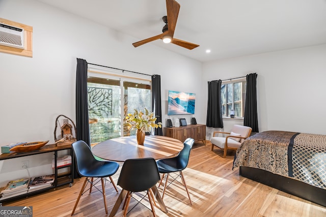 bedroom featuring ceiling fan, an AC wall unit, and light hardwood / wood-style floors