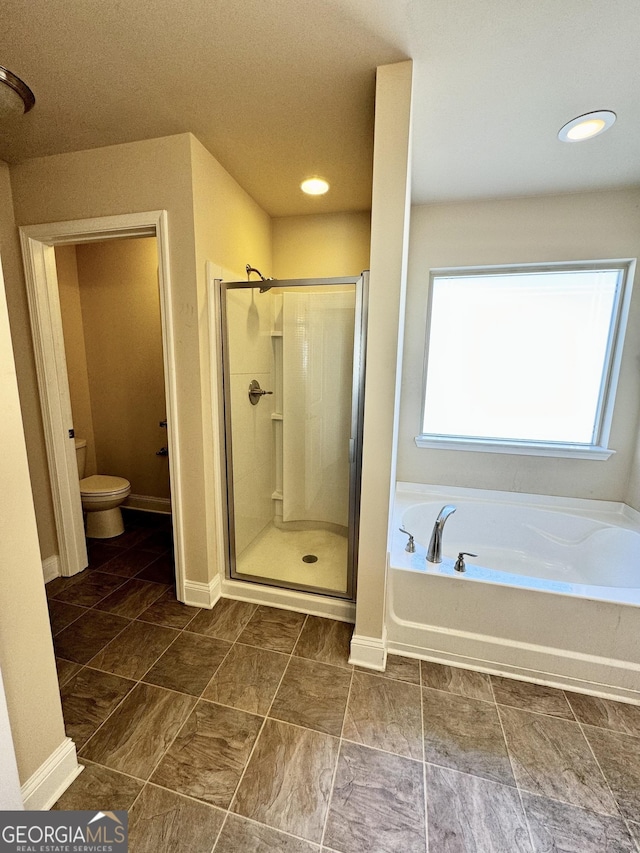 bathroom featuring shower with separate bathtub and toilet