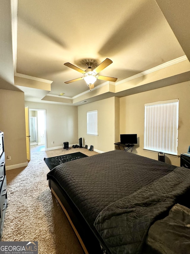 carpeted bedroom with ceiling fan, crown molding, and a tray ceiling